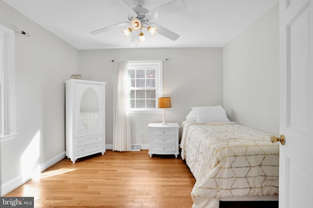 bedroom featuring light wood-style flooring, baseboards, and a ceiling fan