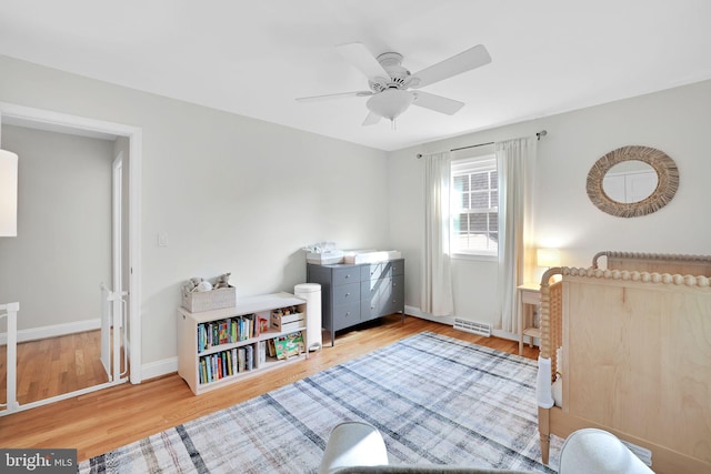 bedroom featuring wood finished floors, baseboards, and a ceiling fan