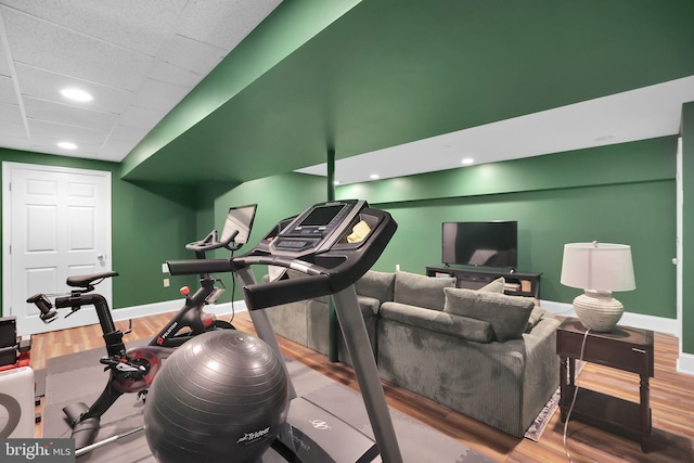 workout area featuring wood finished floors, baseboards, and recessed lighting
