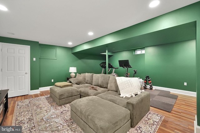 living area featuring baseboards, wood finished floors, and recessed lighting