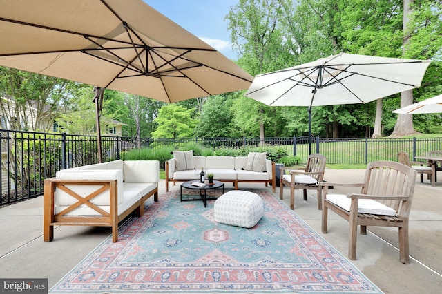 view of patio / terrace featuring outdoor lounge area, fence, and view of wooded area