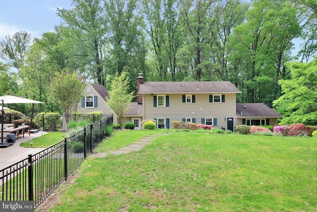 rear view of house with a chimney and a patio