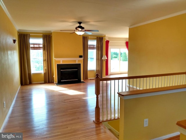 1372 Summerswood Dr, Saint Thomas, PA 17252 - unfurnished living room featuring ornamental molding, healthy amount of natural light, ceiling fan, wood finished floors, and a fireplace with flush hearth