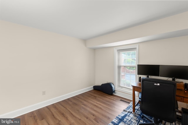 home office with baseboards and wood finished floors