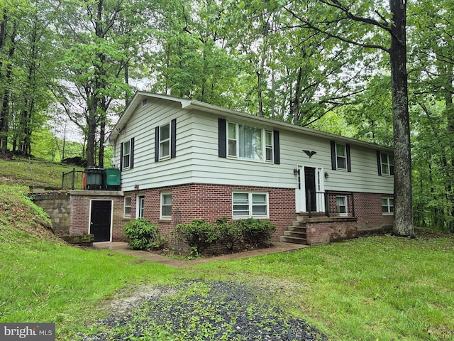 bi-level home with brick siding and a front lawn