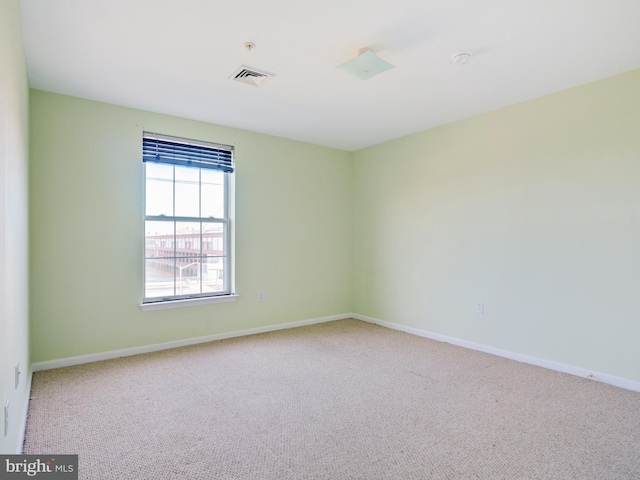carpeted empty room featuring baseboards