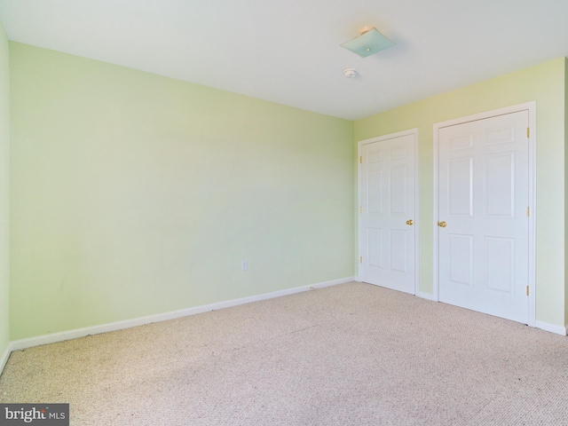 unfurnished bedroom featuring carpet flooring and baseboards