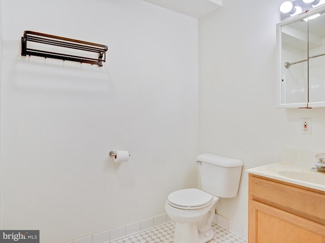 bathroom featuring toilet, vanity, and baseboards