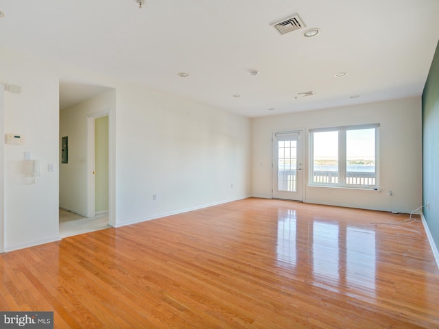 spare room with light wood-style floors, baseboards, recessed lighting, electric panel, and fire sprinkler in ceiling