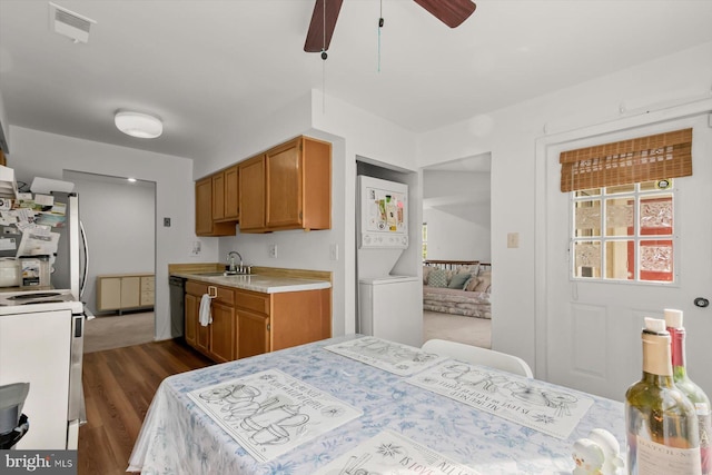 kitchen with range, light countertops, ceiling fan, dark wood finished floors, and a sink
