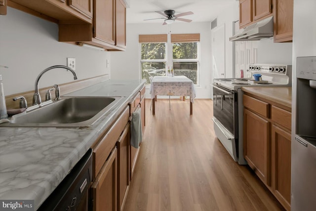 kitchen featuring under cabinet range hood, electric stove, a sink, ceiling fan, and light wood-style floors
