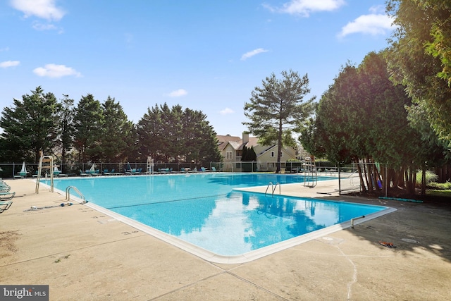 community pool featuring fence and a patio area