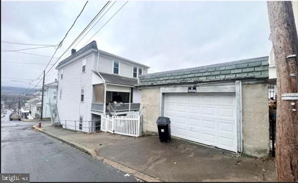 view of side of home featuring an attached garage and driveway