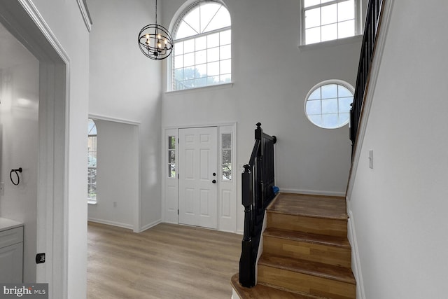 8916 Gladeside Dr, Clinton, MD 20735 - foyer with healthy amount of natural light, a chandelier, light wood-style flooring, and a towering ceiling