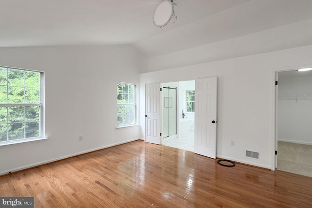 8916 Gladeside Dr, Clinton, MD 20735 - unfurnished bedroom with wood finished floors, lofted ceiling, a walk in closet, connected bathroom, and a closet