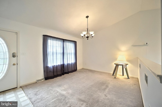entrance foyer with a chandelier, lofted ceiling, baseboards, and carpet floors