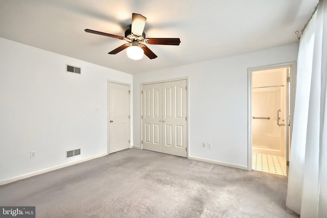 unfurnished bedroom featuring baseboards, carpet, ensuite bath, and a ceiling fan