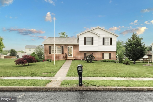 split level home featuring brick siding and a front yard
