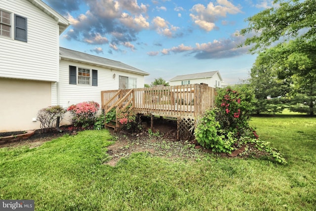 view of green lawn featuring a wooden deck