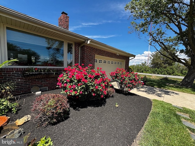 1 Somerset Ave, Cambridge, MD 21613 - view of property exterior featuring a chimney, a garage, and brick siding
