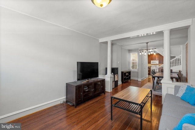 117 E Clement St, Baltimore, MD 21230 - living area with ornate columns, dark wood finished floors, a chandelier, baseboards, and stairs