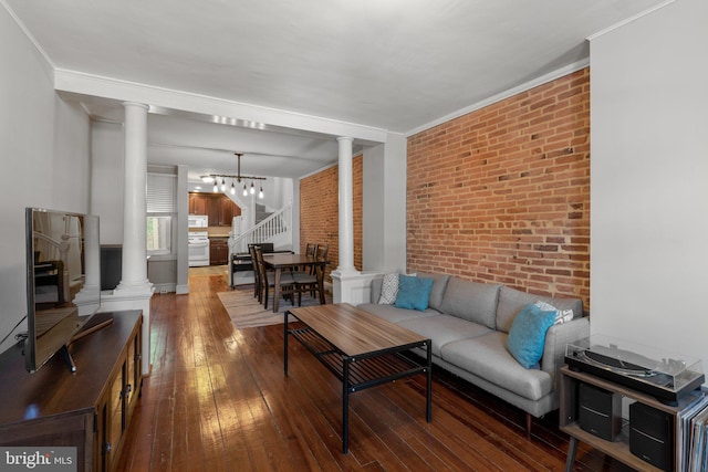 117 E Clement St, Baltimore, MD 21230 - living area with brick wall, ornate columns, stairs, wood-type flooring, and a chandelier