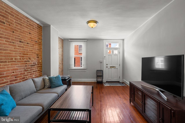 117 E Clement St, Baltimore, MD 21230 - living room featuring brick wall, dark wood-type flooring, and baseboards