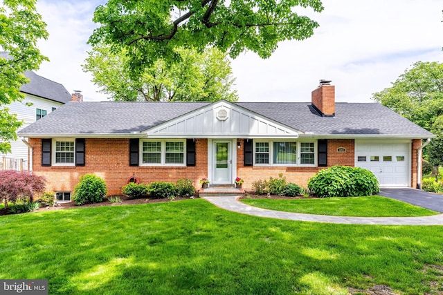 view of front facade with a chimney, brick siding, a garage, and driveway