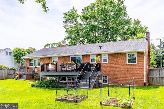 rear view of house with a garden, a chimney, a wooden deck, brick siding, and stairs