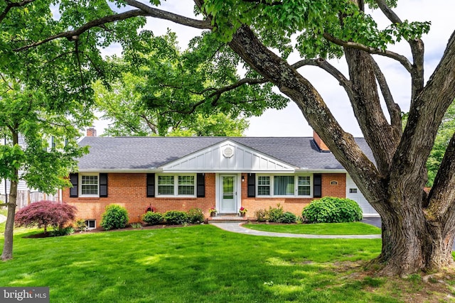 ranch-style home with brick siding, a front yard, board and batten siding, and a chimney