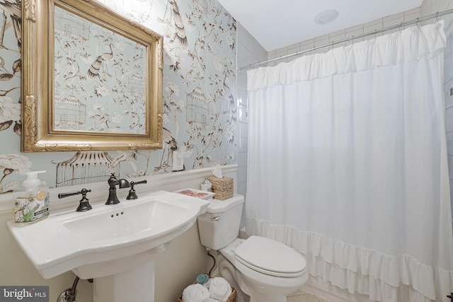 bathroom featuring toilet, wallpapered walls, and a shower with curtain