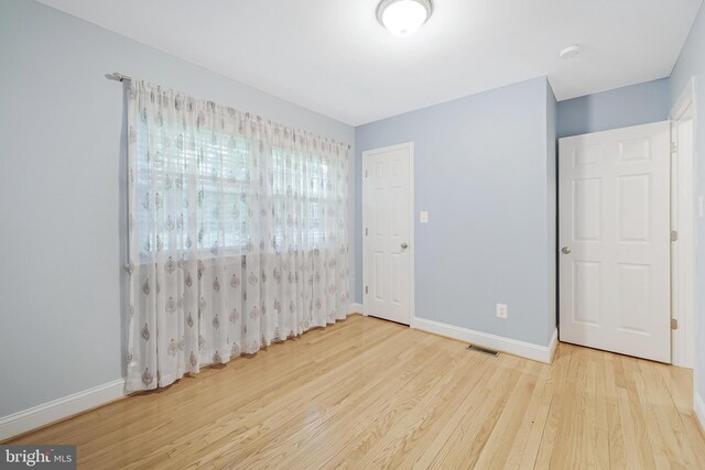 unfurnished bedroom featuring wood finished floors and baseboards