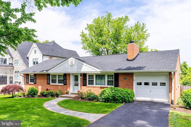 view of front facade with brick siding, a garage, a front lawn, a chimney, and driveway