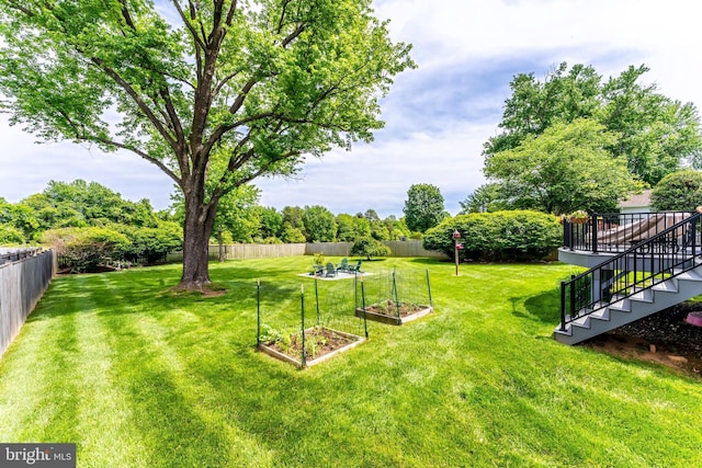 view of yard featuring a vegetable garden and stairway