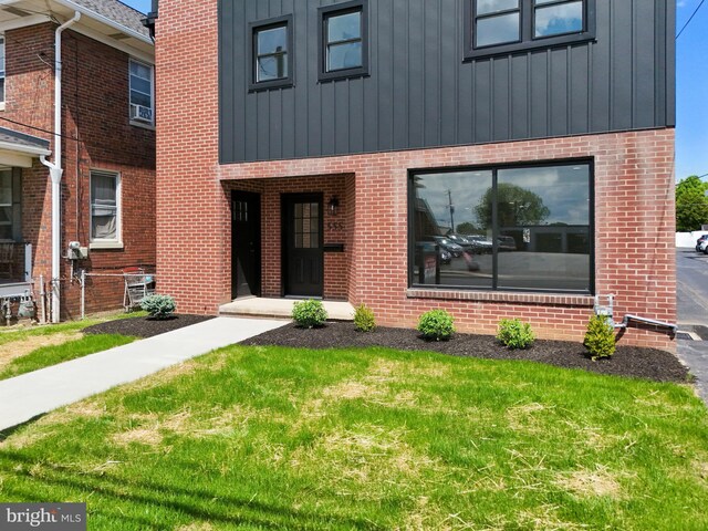 555 Carlisle St, Hanover, PA 17331 - view of front of home with board and batten siding, brick siding, and a front yard