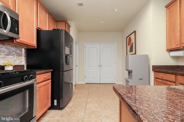 9712 Handerson Pl Unit 306, Manassas Park, VA 20111 - kitchen with stainless steel appliances, decorative backsplash, light tile patterned floors, dark stone countertops, and baseboards