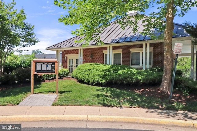 9712 Handerson Pl Unit 306, Manassas Park, VA 20111 - view of front of house featuring a standing seam roof, metal roof, a front lawn, and brick siding