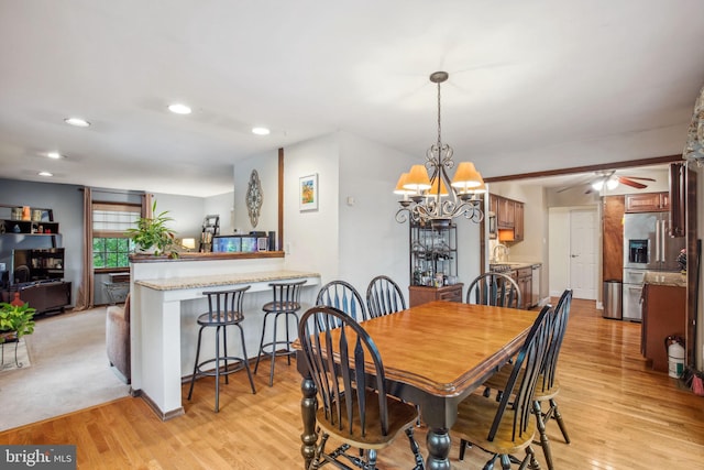 dining room featuring light wood-style floors, recessed lighting, a ceiling fan, and a chandelier
