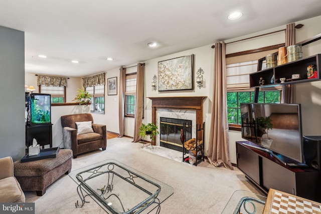 carpeted living room with a high end fireplace, recessed lighting, and plenty of natural light
