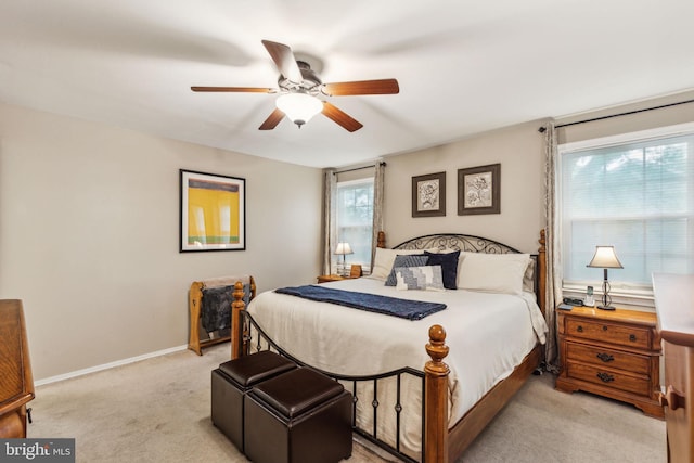 bedroom featuring light carpet, a ceiling fan, and baseboards