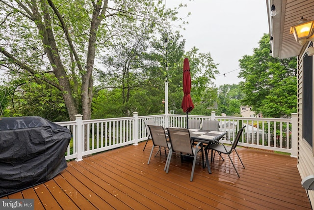 deck featuring outdoor dining space and view of scattered trees