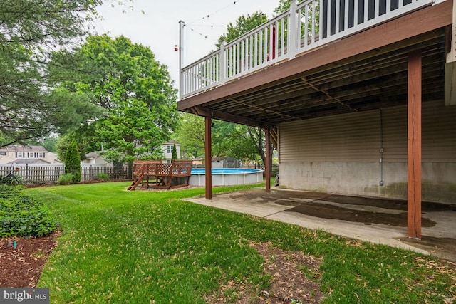 view of yard featuring an outdoor pool, a wooden deck, and a patio area