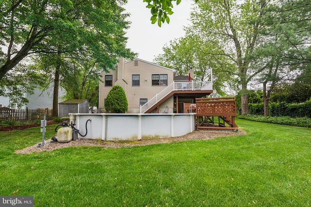 back of property with stairway, a deck, a shed, and an outbuilding