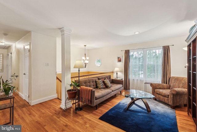 living room with light wood finished floors, baseboards, and a chandelier