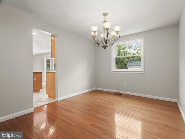 10205 Scaggsville Rd, Laurel, MD 20723 - unfurnished room with light wood finished floors, a chandelier, and baseboards