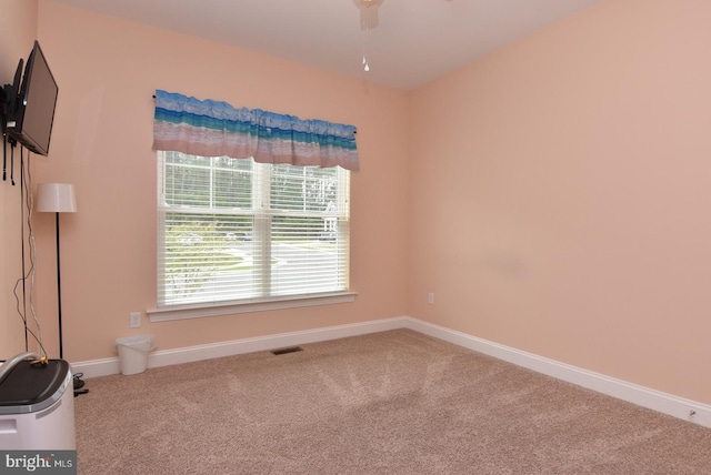 empty room with carpet floors, ceiling fan, and baseboards