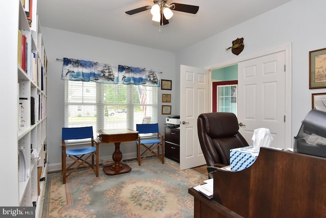 office area with a ceiling fan and baseboards