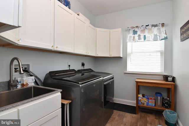 clothes washing area featuring cabinet space, washer and dryer, dark wood-style floors, and baseboards