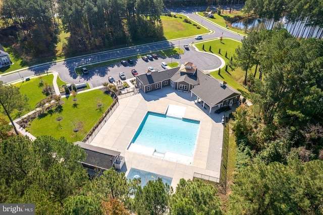 drone / aerial view of a pool and a large body of water