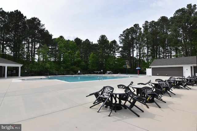 community pool with a patio and view of scattered trees